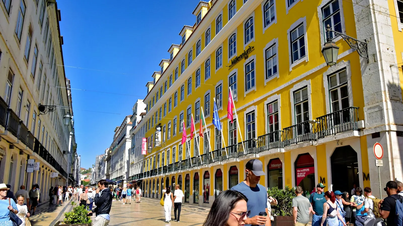 Rue ensoleillée bordée de façades jaunes dans le centre de Lisbonne
